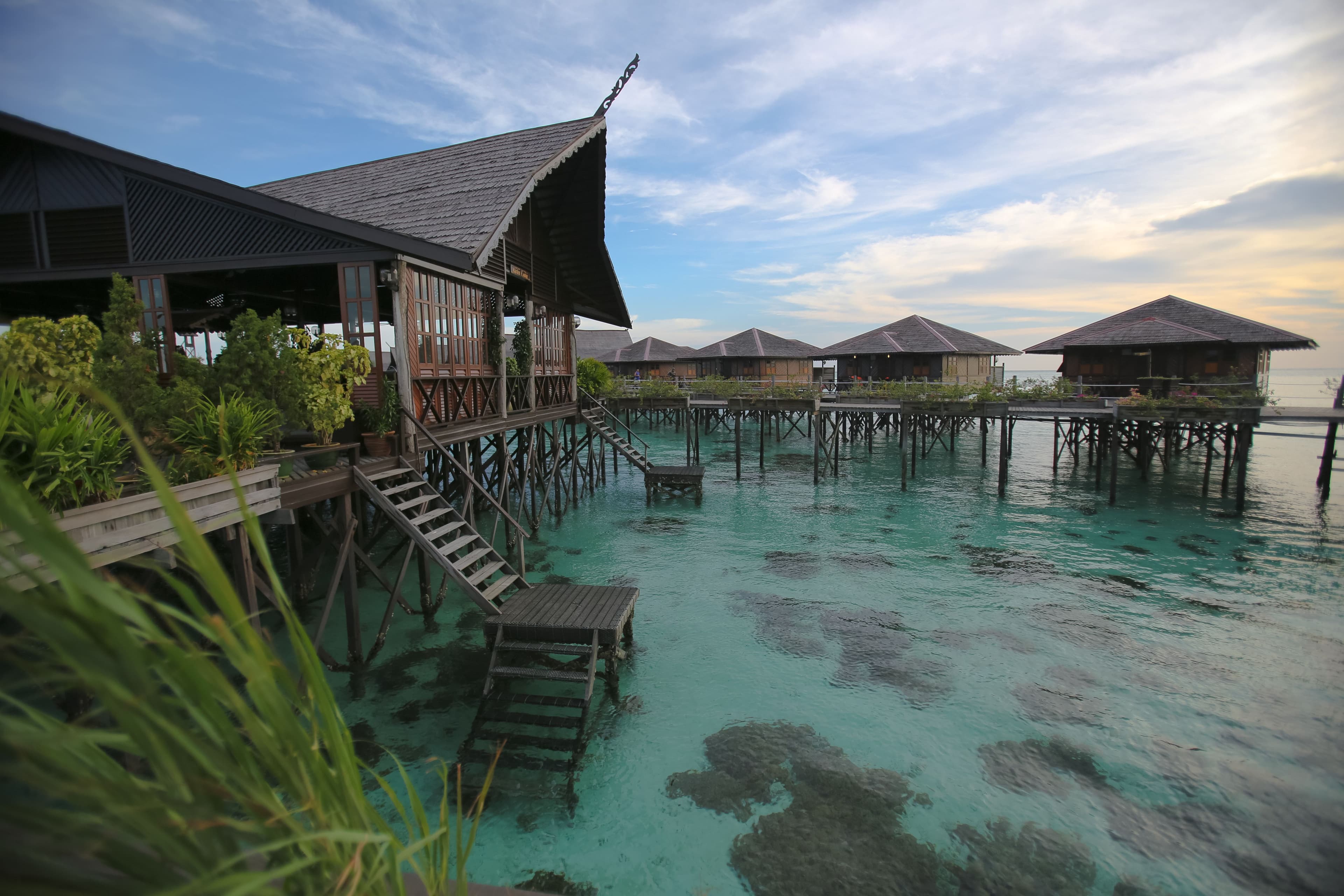 An overwater resort bungalow at sunset
